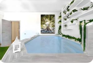 a swimming pool in a white room with a tree painting on the wall at Penthouse Station luxury apts Le dimore in Brindisi
