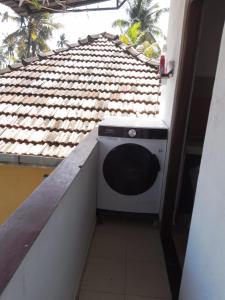 a washing machine in a balcony with a roof at jenul villa in Ahangama