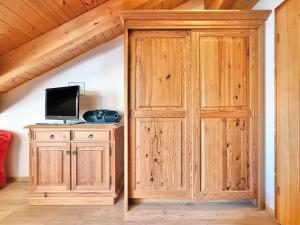 a large wooden closet with a tv and a television at Sonnenhof Seeg 16 in Seeg