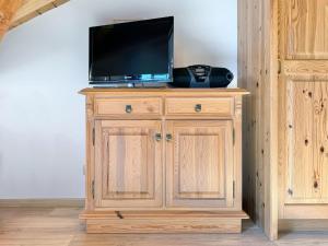 a wooden cabinet with a television on top of it at Sonnenhof Seeg 16 in Seeg