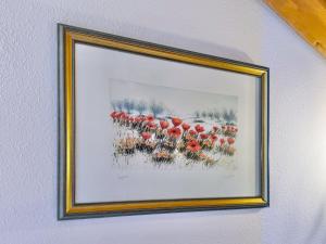 a framed painting of red flowers on a wall at Sonnenhof Seeg 16 in Seeg