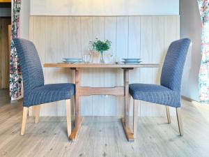 a wooden table with two blue chairs and a table with at Sonnenhof Seeg 16 in Seeg +22 photos