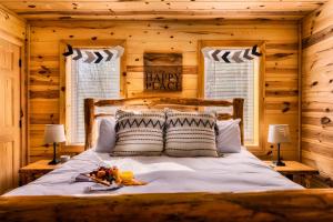 a bedroom with a bed in a log cabin at Take It Easy - 5 Star Family Cabin View Hot Tub FirePit Pools Bears in Gatlinburg