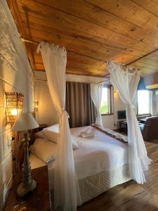 a bedroom with a bed with drapes on it at Pousada do Rei Arthur in Lavras Novas +63 photos