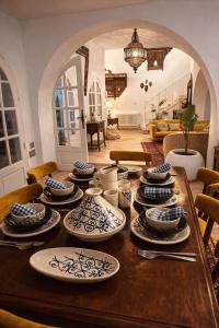 a wooden table with blue and white dishes on it at Maison Lella Kmar Sidi Bou said in Sidi Bou Saïd