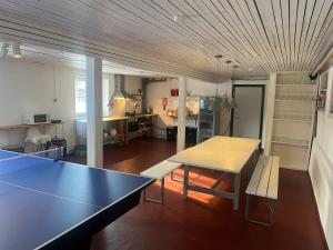 a living room with a table and bench and a kitchen at Rinkenæshus Hytte B in Gråsten