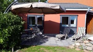a patio with a table and chairs and an umbrella at Ferienhaus Hummel in Böhl