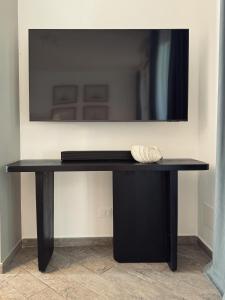 a black table with a television on a wall at Grecale - Villa Marina in Marina di Andora