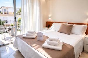 a bedroom with a large bed with towels on it at Hotel Regal in Rimini