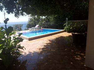 a swimming pool with a chair next to the ocean at Apartment Sofia in Sutomore +6 photos