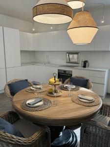a kitchen with a wooden table and some chairs at Grecale - Villa Marina in Marina di Andora