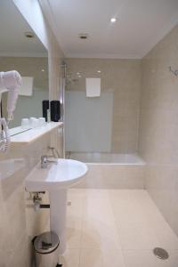 a bathroom with a sink and a bath tub at Hotel Gabriel y Galán in Salamanca