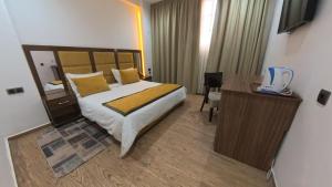 a bedroom with a bed and a desk with a telephone at Hôtel Sable d'Or in Tan-Tan