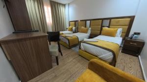 a hotel room with two beds and a television at Hôtel Sable d'Or in Tan-Tan