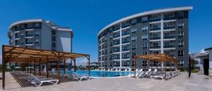 a hotel with a swimming pool in front of two buildings at Palmora Lara Hotel in Aksu