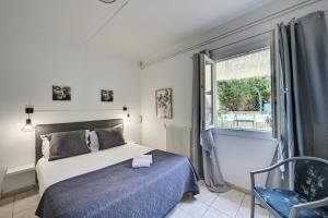 a bedroom with a bed and a window and a chair at Logis Hôtel La Bastide d'Entraigues in Entraigues-sur-la-Sorgue +51 photos