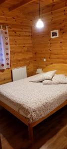 a bedroom with a bed in a wooden wall at Les Chalets du Choumeau in Saint-Léger-les-Mélèzes