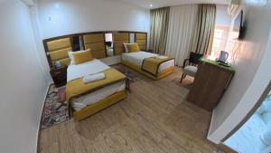 a large hotel room with two beds and a television at Hôtel Sable d'Or in Tan-Tan
