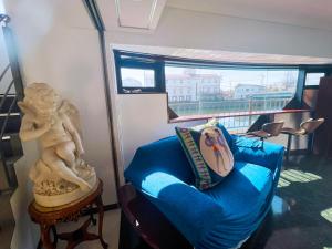 a living room with a blue couch and a statue at ゲストハウス 清水銀座 in Shizuoka +14 photos