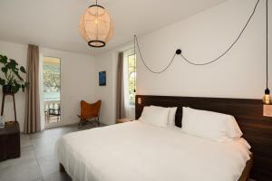 a bedroom with a large white bed and a window at Villa Patria B&B in Brusino Arsizio