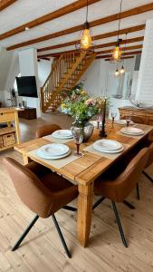 a wooden table with plates and flowers on it at Ferienwohnung Lerchi's Ankerplatz in Barßel