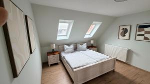 a bedroom with a bed with two night stands and two windows at Ferienwohnung Lerchi's Ankerplatz in Barßel
