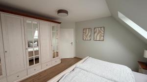 a white bedroom with a bed and a window at Ferienwohnung Lerchi's Ankerplatz in Barßel