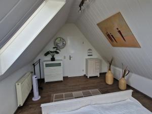 a attic room with a staircase with white walls at Ferienwohnung Lerchi's Ankerplatz in Barßel +19 photos