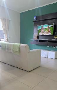 a white couch in a living room with a tv at San Juan Santo Tome in Santo Tomé