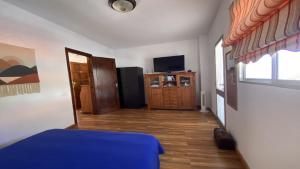 a living room with a blue couch and a television at El Chorro Atico in Calera