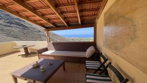 a porch with a bench and a table and chairs at El Chorro Atico in Calera