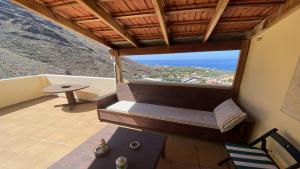 a balcony with a bench and a table and the ocean at El Chorro Atico in Calera