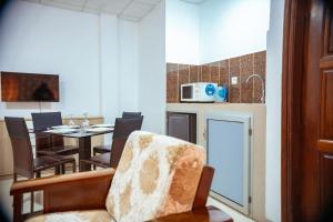 a kitchen and dining room with a table and a chair at Guest House Lumen in Lomé