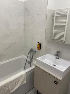 a white bathroom with a sink and a bath tub at Happy apartment 1 in Roşu +9 photos