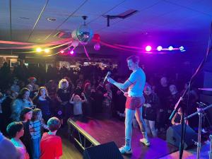 a man standing on a stage in front of a crowd at Tencreek Holiday Park in Looe +290 photos
