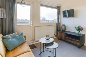 a living room with a couch and a table at Appartementen Parkzicht in Bergen aan Zee