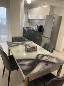 a kitchen with a dining table with chairs and a counter top at Happy apartment 1 in Roşu