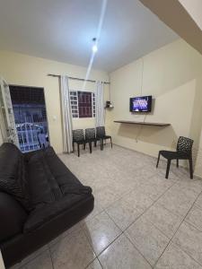 a living room with a couch and chairs and a tv at Casa para 5 pessoas, 1 vaga de garagem, wi-fi, próximo EMS in Hortolândia