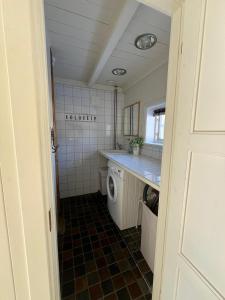 a small bathroom with a washer and dryer at Cosy Cottage Vollheim in Lillehammer +43 photos
