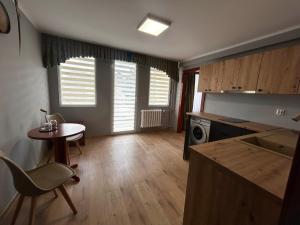 a living room with a table and a kitchen with a tableablish at Hotel Pietrak in Trzemeszno
