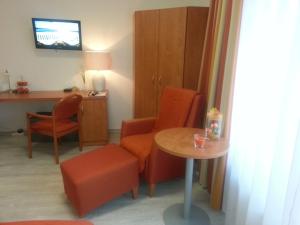 a living room with a table and chairs and a desk at Sonniges Studio im Haus Deutsch Krone in Bad Rothenfelde