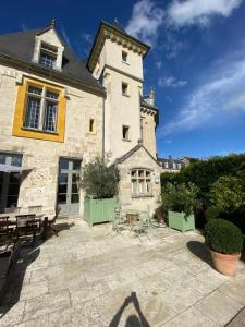 a large stone building with a patio at Le Castel Ecossais in Senlis