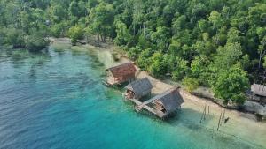 an aerial view of three houses in the water at Rosye homestay raja ampat in Fam