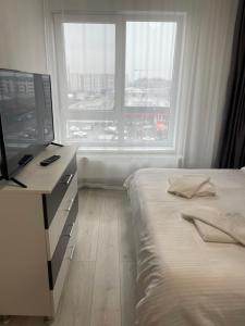 a bedroom with a bed and a desk and a window at Happy apartment 1 in Roşu