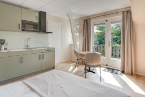 a kitchen with a table and chairs and a window at Appartementen Parkzicht in Bergen aan Zee