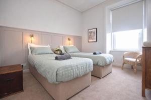 a bedroom with two beds and a window at Portside Apartment in Greenock