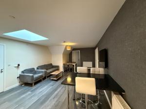 a living room with a couch and a table at Magna House in Egham