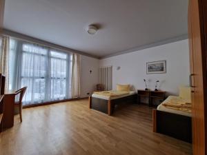 a bedroom with two beds and a large window at Gästehaus Dominikus in Leipzig +38 photos