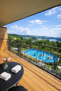 a balcony with a view of a swimming pool at apartamentwroznowiepl in Rożnów
