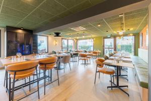 a dining room with tables and chairs and windows at Campanile NATURE - Lyon Est Bron Eurexpo in Bron +37 photos